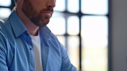 Man Typing on Laptop, Thinking at Desk