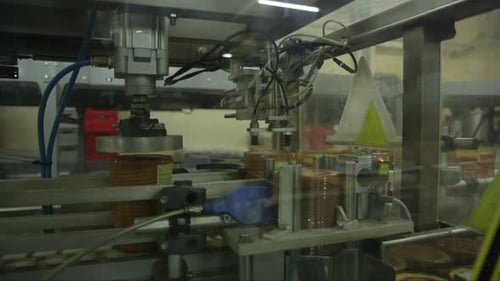 Robotermaschine setzt Plastikkappen auf Crackerverpackungen in einer Lebensmittelfabrik