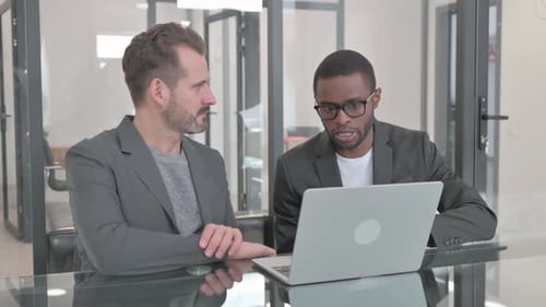 Men Discuss Business in Modern Office With Laptop