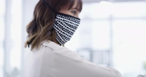 4k video footage of two businesswoman wearing masks and bumping elbows in a modern office