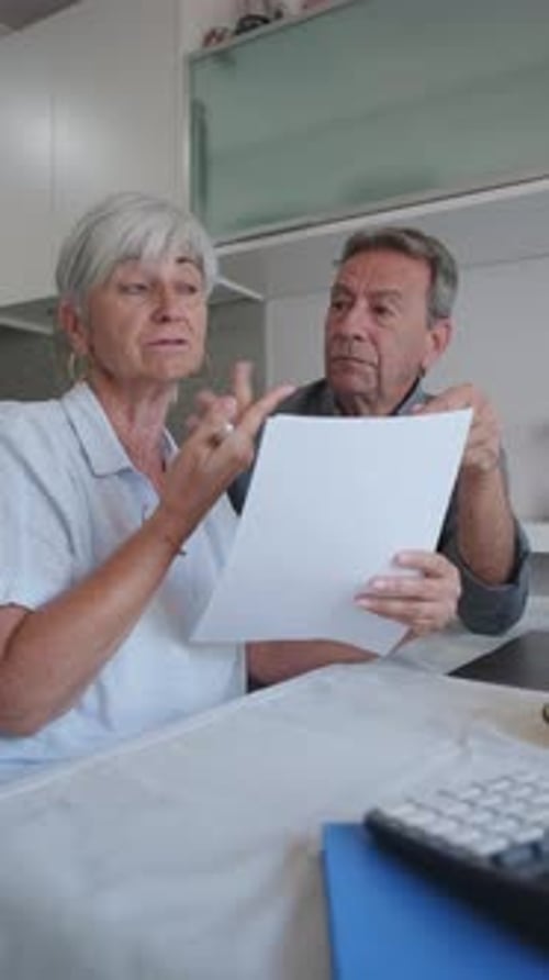 Senior Couple Reviewing Documents at Indoor Table