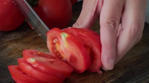 Slicing Ripe Red Tomatoes on Cutting Board