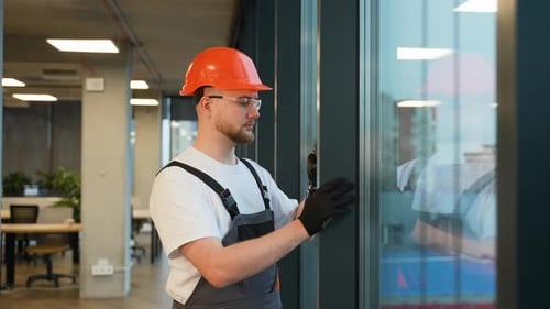 Construction Worker Installing Window in Office Building