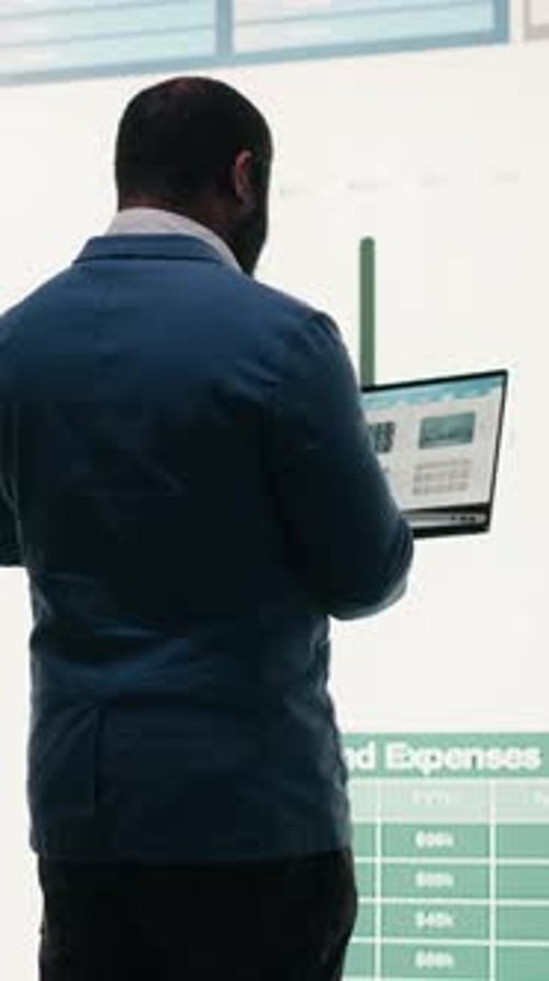 Vertical Video Analyzing Revenue Laptop and Manager Looking at Expenses
