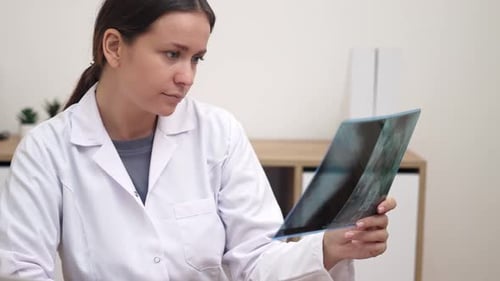 Woman Doctor Analyzing X-Ray in Hospital