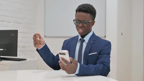 Man in Suit Using Smartphone in Office