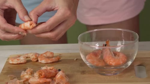Preparing Shrimp by Peeling Shells on Cutting Board