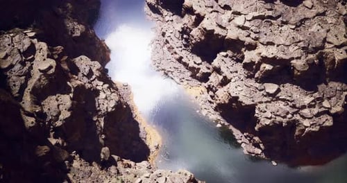 Rugged Rock Formations Surround Tranquil Water in a Secluded Canyon Area