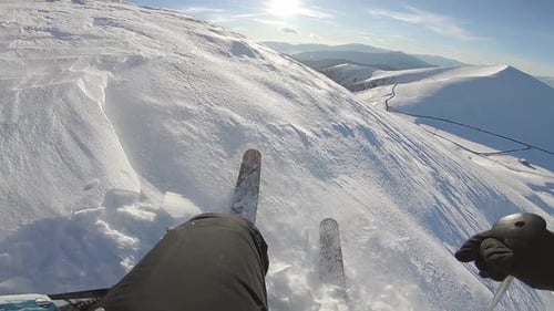 First Person Skiing Down Snowy Mountain Slope