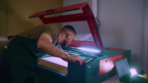Techniker bedient Lasergravurmaschine in der Werkstatt