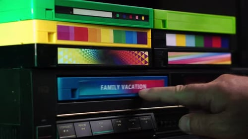 Loading Family Vacation VHS Video Cassette Tape Recording Into VCR, Close Up