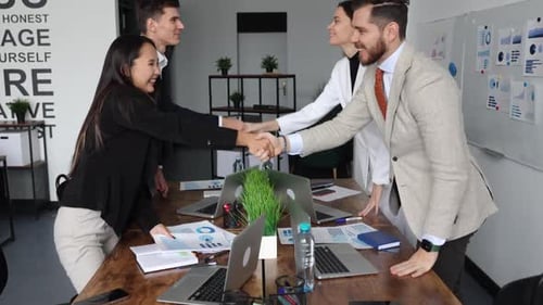 Employees of Companies After Successful Negotiations at the Table Shake Hands