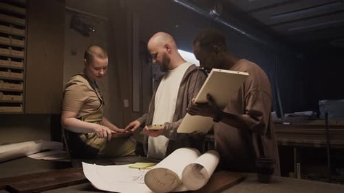 Young Furniture Makers Choosing Material for Woodworking Project in Workshop