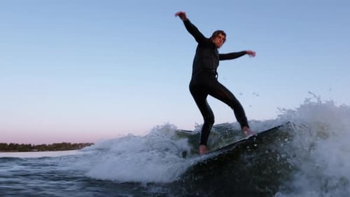 Dynamic Surfing Sequence A Skilled Surfer Riding Waves with Precision and Balance Against a