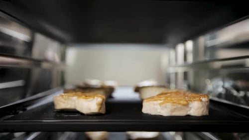 Close-up of grilled pork belly slices in an oven, showcasing sizzling and delicious details