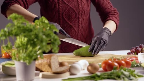 Person Slicing Avocado in a Kitchen