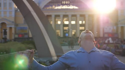 Young Businessman Celebrating Achievement Standing at City Environment