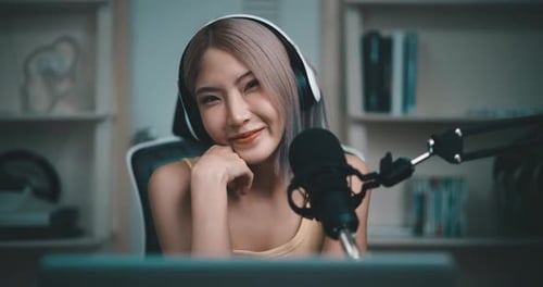 Young Woman Waving Into Microphone for Livestream