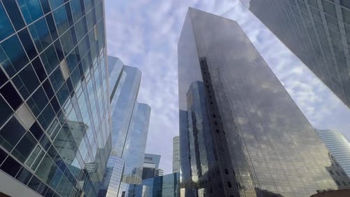 The Glass Skyscrapers Reflect the Blue Sky with Clouds