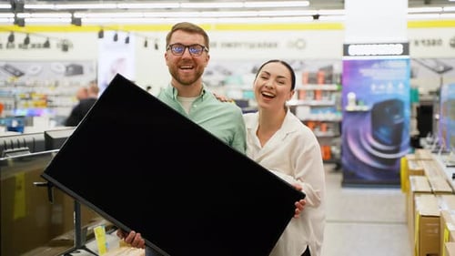 Happy Couple with New Television in Tech Store