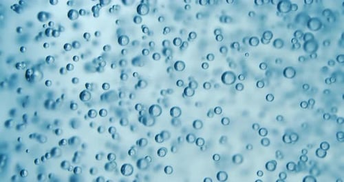 Many water bubbles in blue water close up, abstract water wave with bubbles in slow motion.