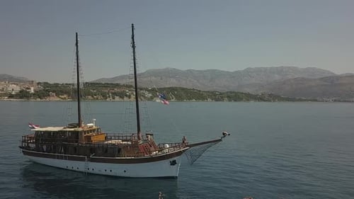 Slow motion : un touriste plonge dans la mer depuis la proue d'un bateau d'excursion croate