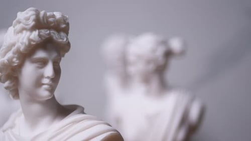 Statue du dieu grec Hermès avec d'autres personnages flous, de droite à gauche