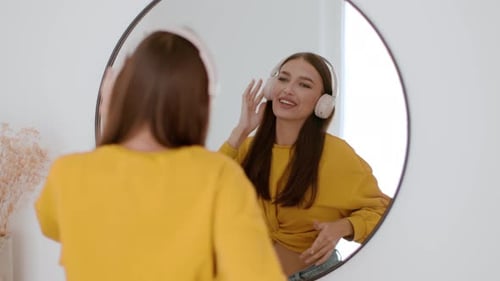 Woman Dancing and Singing with Headphones in Mirror