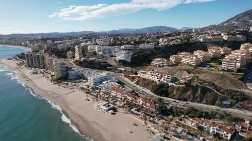 Cityscape Fuengirola drone view with blue summer sky, buildings and sea coast background
