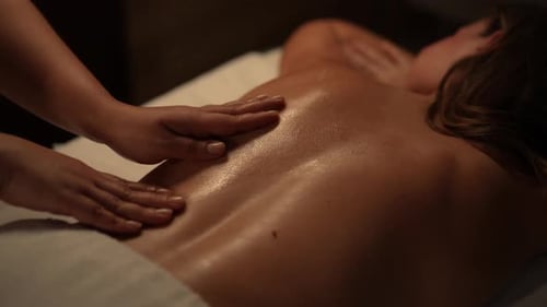 Woman Receiving Relaxing Back Massage in Spa
