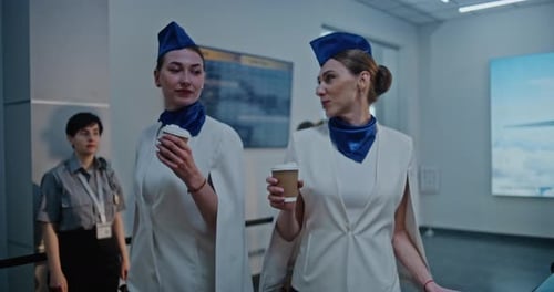 Airport Terminal Two Flight Attendants Walking for Boarding Commercial Flight with Airline Pilot