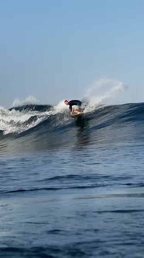 Young Man Surfs in the Ocean