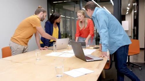 A diverse team collaborates in a casual business, modern office setting, with copy space