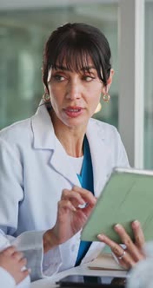 Woman in Lab Coat Using Tablet in Hospital