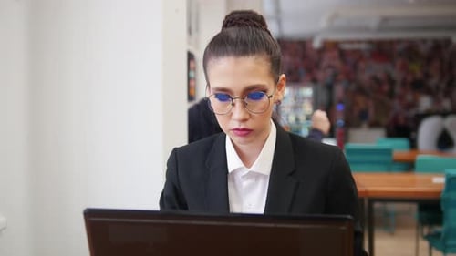 Professional Woman Working on Laptop in Bright Office