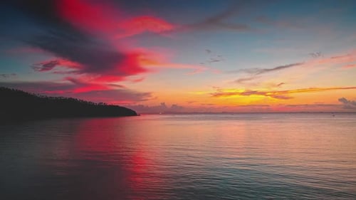 Farbenfroher Sonnenuntergang, der sich auf ruhigem Meer am Strand von Koh Ma spiegelt, Insel Koh Phangan, Thailand