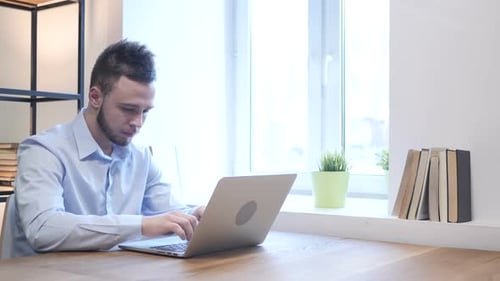 Young Adult Working on Laptop at Home