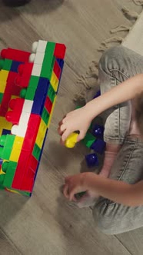 Child Playing with Colorful Building Blocks at Home