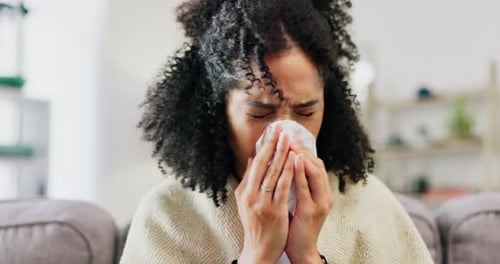 Woman Blowing Nose with Tissue at Home