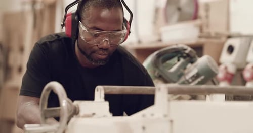 Woodworker using woodworking machine inside a factory