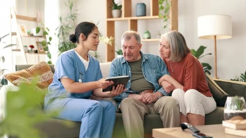 Caregiver Showing Tablet Information to Senior Couple