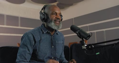Mature Male Podcaster in Studio Recording Business Podcast