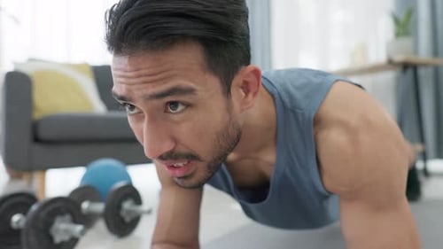 Man doing plank exercise, fitness and workout in the living room on the floor