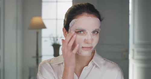 Beauty shot of young woman wearing paper sheet facial mask ready for moisturizing anti wrinkle day