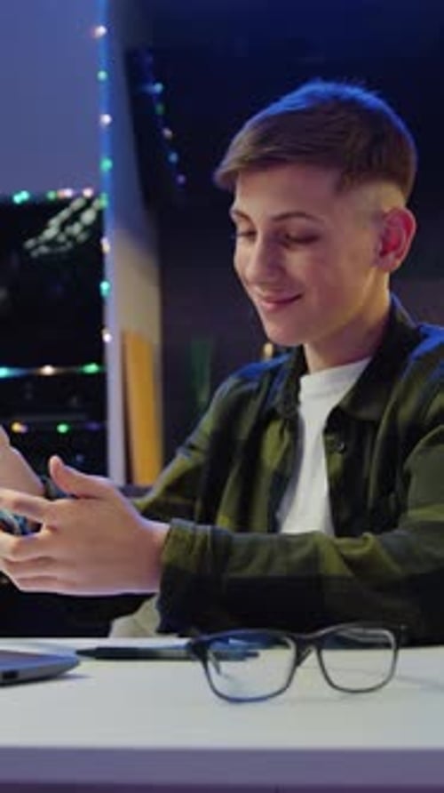 Teenager Plays Game on Phone at Home