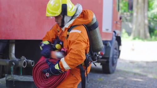 Firefighter Connecting Fire Hose to a Fire Truck