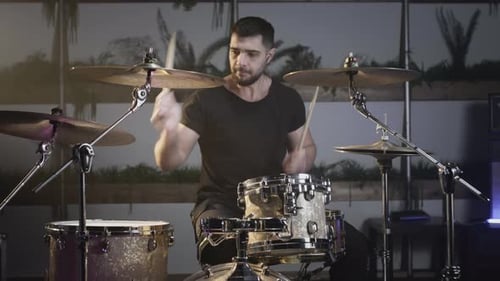 Drummer Plays Drum Kit with Energy in Studio