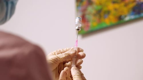 Closeup Nurse Draws Vaccine From an Ampoule Into a Syringe