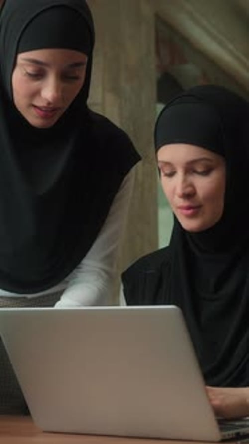 Professional Women Working Together on Laptop in Office