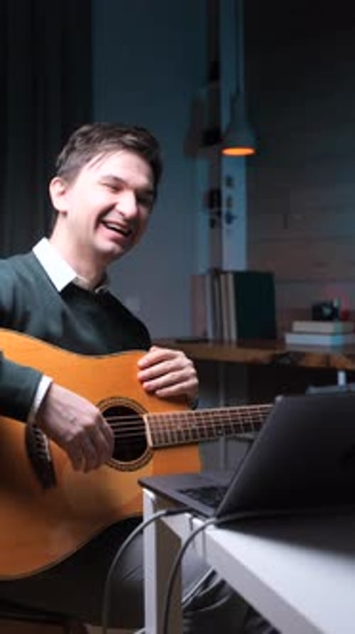 Young Adult Playing Acoustic Guitar at Home